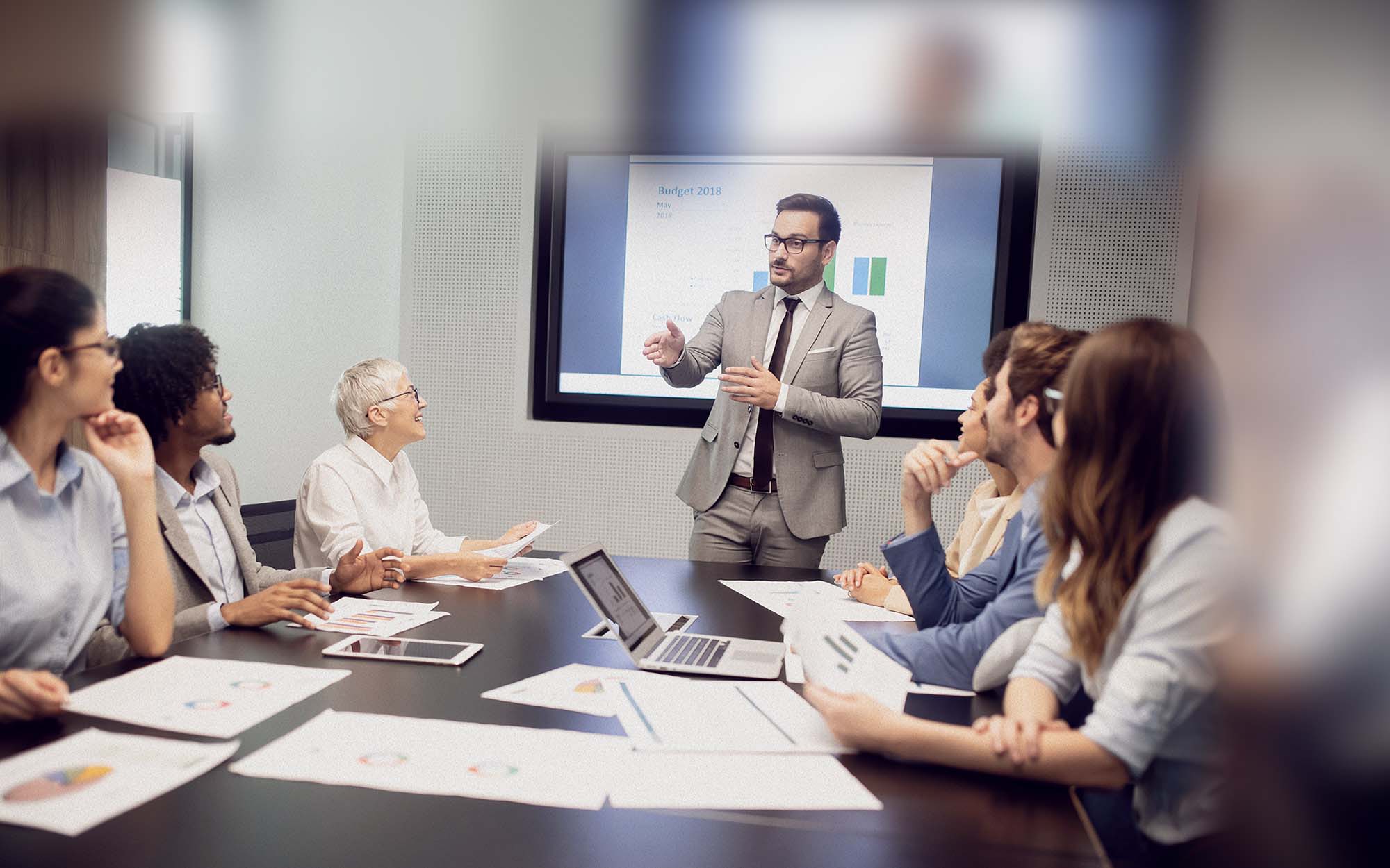 Man giving presentation to group at conference table